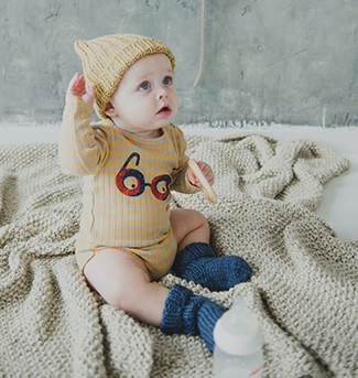 A baby wearing a yellow hat and onesie
