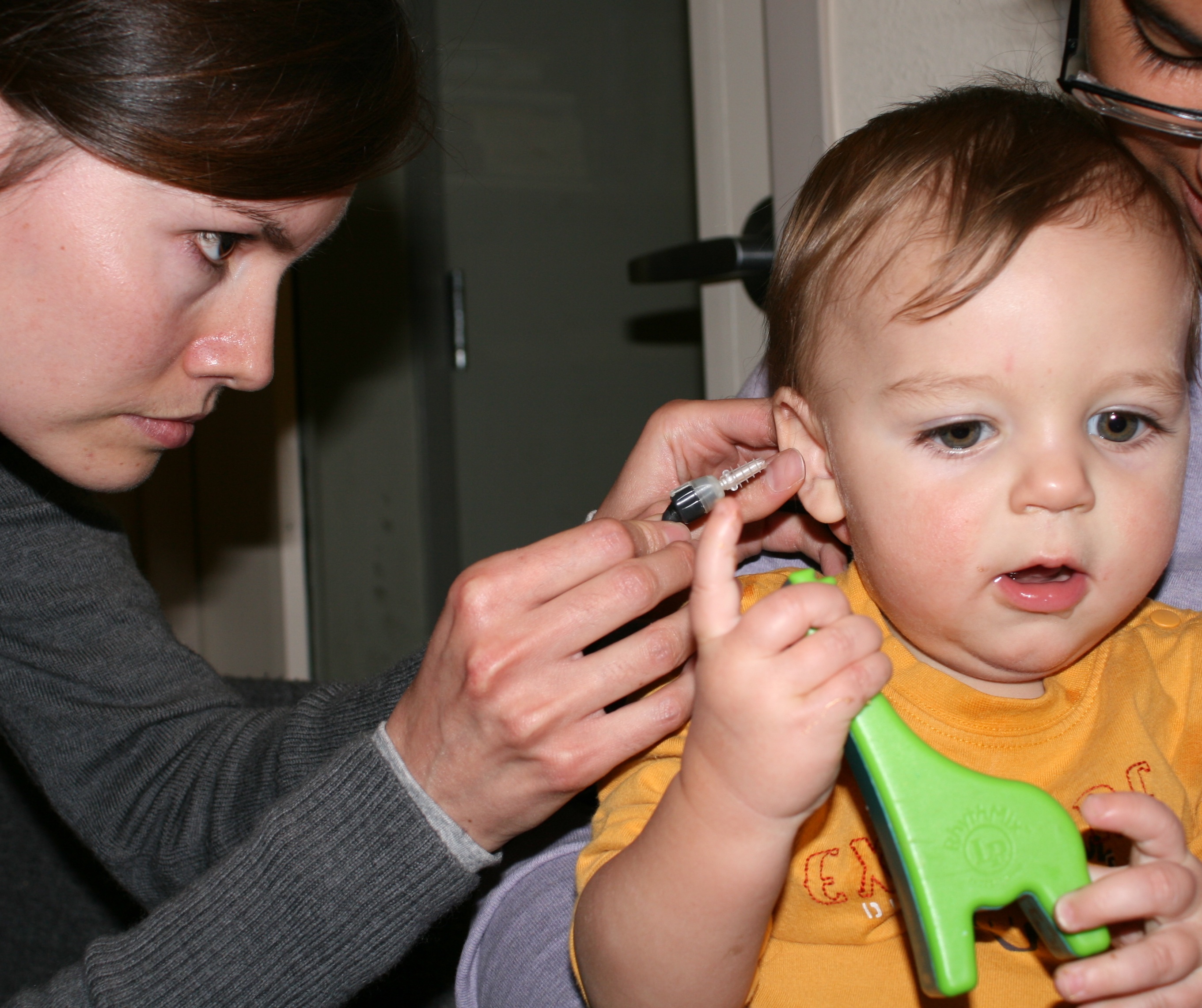 a boy playing with toys while getting a hearing screening