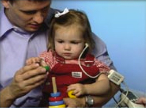 a man conducting a hearing screening test with a young girl