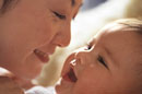 a woman and a baby smiling at one another