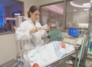 a woman performing a newborn hearing screening test
