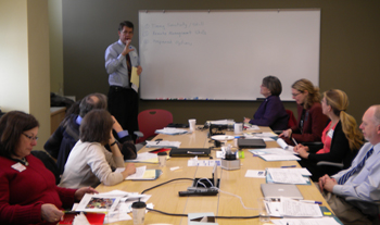 a group of professionals discussing TI around a conference table