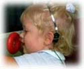 Figure G: an infant during bone conduction testing, a testing instrument behind the left ear