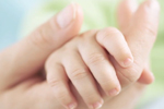 a child's hand cupped in an adult hand