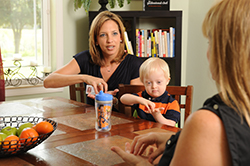 a mom and her son practicing signing with an early intervention specialist